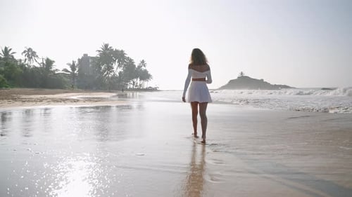 Attractive Model with Bouquet of Flowers Walking Barefoot in Sea Surf on Tropical Island Romantic