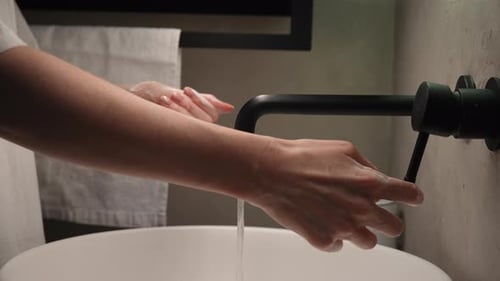 Woman Washing Hands With Soap in Modern Bathroom