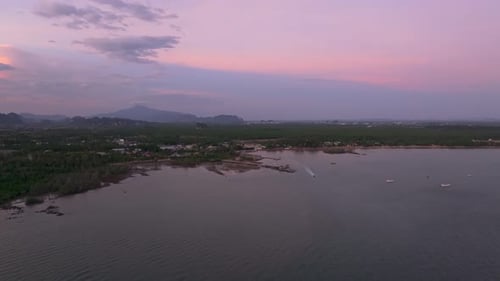 Longtail boats gently glide past islands at golden hour, Thailand