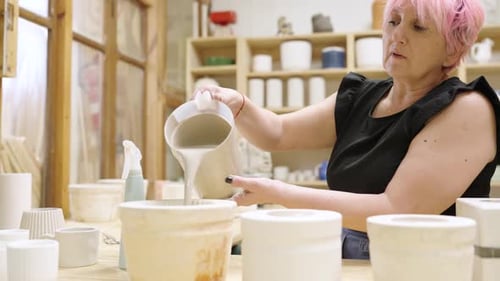 Woman in Studio Filling Pottery With Liquid Clay