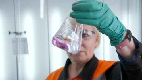 Scientist Observes Chemical Liquid in Glass Flask
