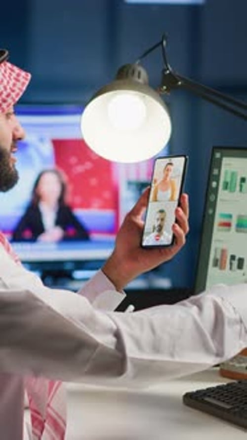 Middle Eastern Man Uses Phone for Virtual Meeting