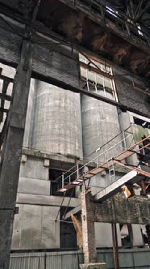 Ruins of an old factory. Interior of an abandoned derelict industrial structure. Vertical video