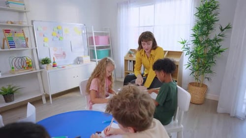 Teacher Helping Young Students with Drawing Activity