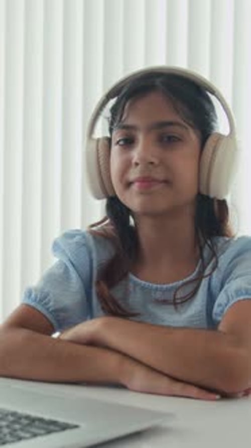 Smiling Girl with Headphones at Laptop