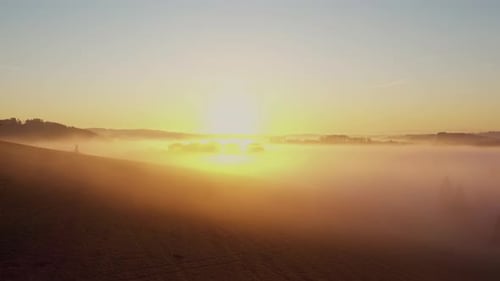 Golden sky above misty fields