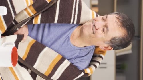 Man Wrapped in Blanket Showing Signs of Illness
