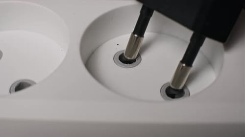 Close Up of Black Plug Going Into Outlet