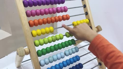 Niño pequeño jugando con un bonito ábaco colorido juega con un ábaco de madera en casa Un niño pequeño tiene