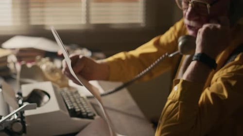 Senior Author Discussing Deadline of Book with Publisher Over Retro Phone