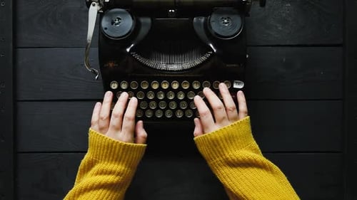 Hand der jungen Schriftstellerin auf alter Schreibmaschine