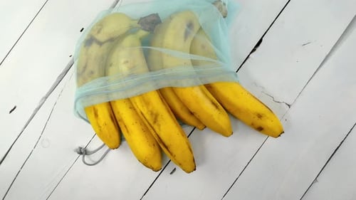 Un montón de plátanos maduros en una cuadrícula ecológica giran sobre fondo blanco