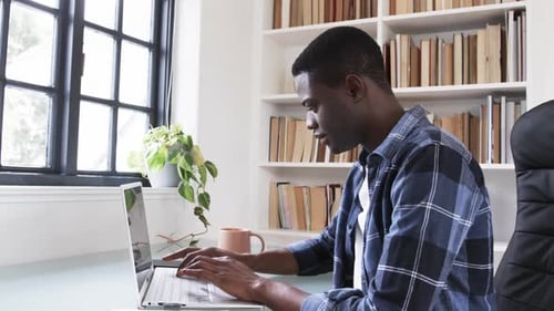 Young Adult Working on Laptop at Home