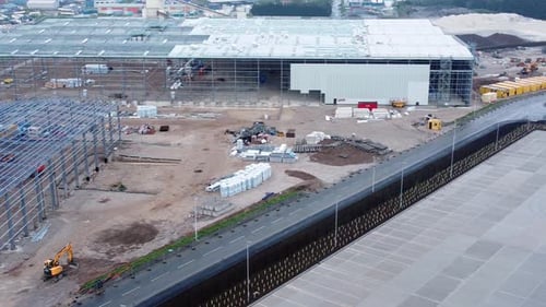 Vista aérea del sitio de construcción de un edificio industrial moderno sin terminar con estructura de acero