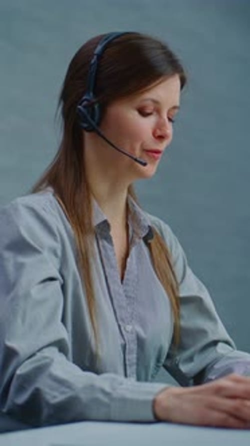 Call Center Female Hotline Operator Talks on Headset with Customer Works on Computer