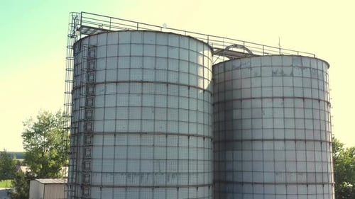 Large Industrial Grain Silos Standing Tall Under a Bright Sky