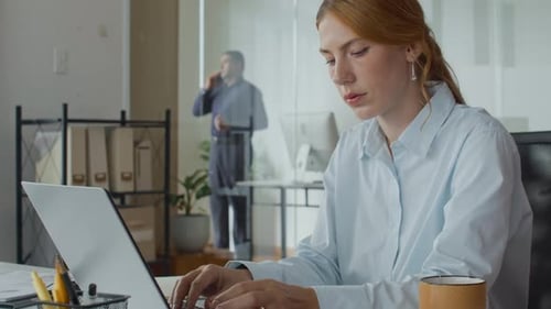 Woman Typing at Desk in Modern Office