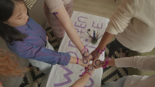 Female Activists Putting Feminist Symbols on Fists Together Top View