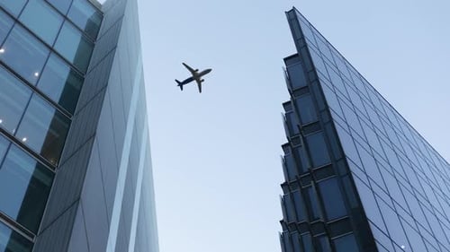 Airplane Flying Over Office Buildings. Business Success Concept.