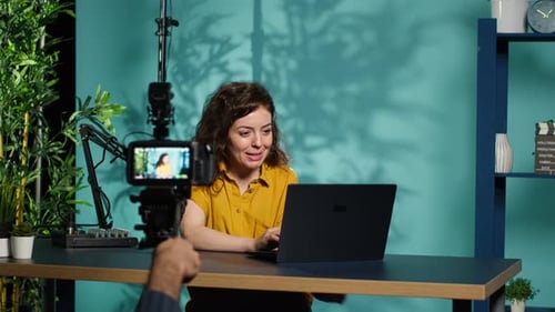 Woman Recording Video with Laptop and Microphone