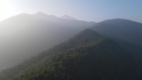 Aerial view foggy and misty forest in Mountain with sun ray in the morning