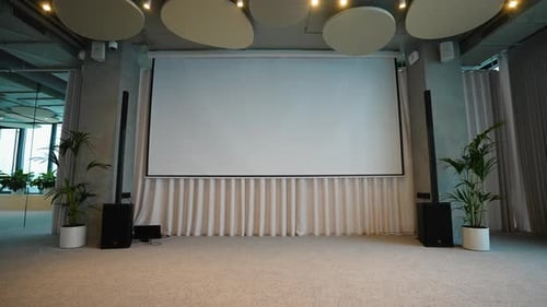 White Projector Screen Closing in Modern Conference Hall