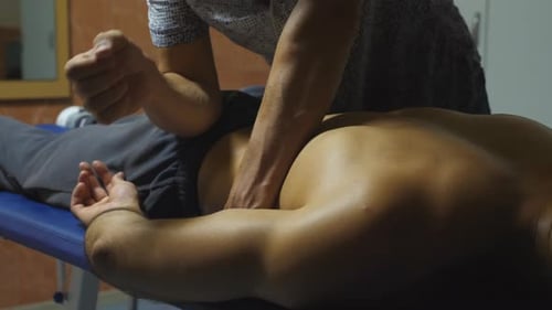 Man Getting Back Massage at Clinic