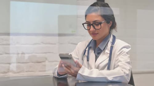 Indian Female Doctor Working on Phone in Hospital