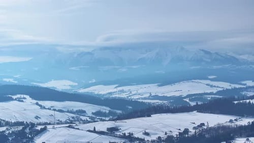 Aerial view of snow-covered mountains in winter landscape