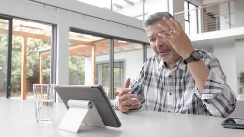 Man Video Chatting on Tablet at Home