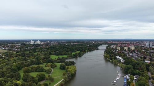 Farbige Bäume im Park in der Nähe des Sees von American Town an bewölkten Herbsttagen. Weitwinkelaufnahme aus der Luft.