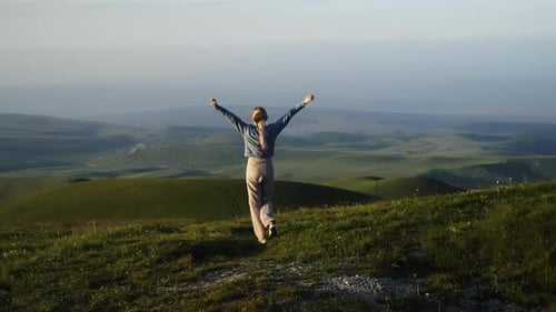 A Woman Walking on a Hill A Woman Standing on a Hill with Her Arms Outstretched Amidst the Untamed