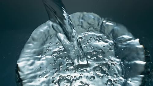 Primer plano de vidrio transparente para verter agua mineral. Líquido suave con numerosas ampollas