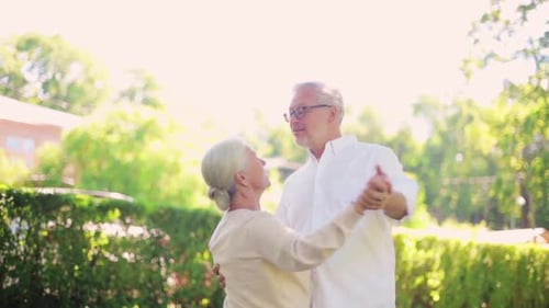 Old Age, Relationship And People Concept - Happy Senior Couple Dancing Waltz At Summer City Park
