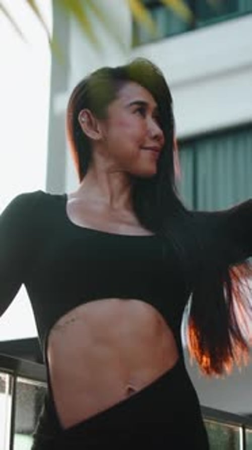 Woman in Athletic Wear Poses on City Balcony