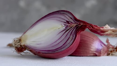 De cerca, la mitad de las cebollas rojas frescas de Tropea, volteadas sobre una mesa blanca