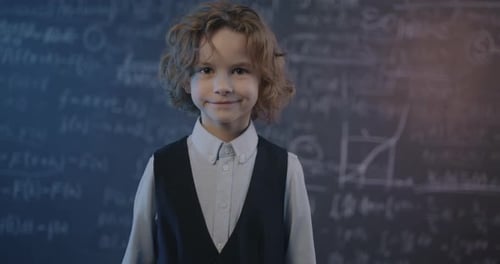 Young Child Standing in Front of Chalkboard