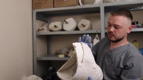 Man Examining Plaster Mold in Medical Facility
