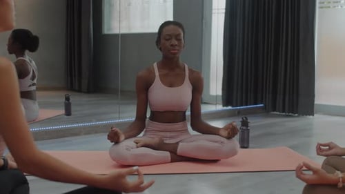 Young Adults Meditating in a Bright Yoga Studio