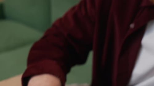 Employee Using Laptop Talking on Smartphone at Office