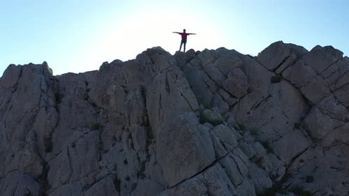 Man Standing on Mountain Top Arms Outstretched
