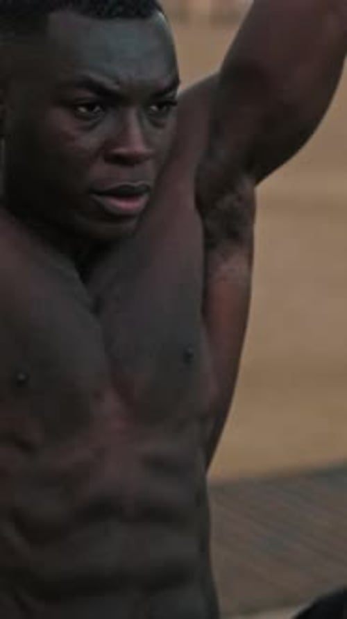 Nahaufnahme eines athletischen Mannes ohne Hemd, der Klimmzüge an einer Bar im Freien macht, muskulöser männlicher Torso