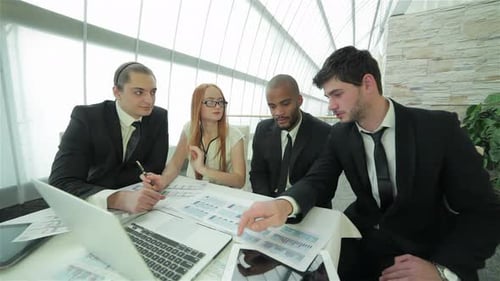 Business Team Working at Table with Charts