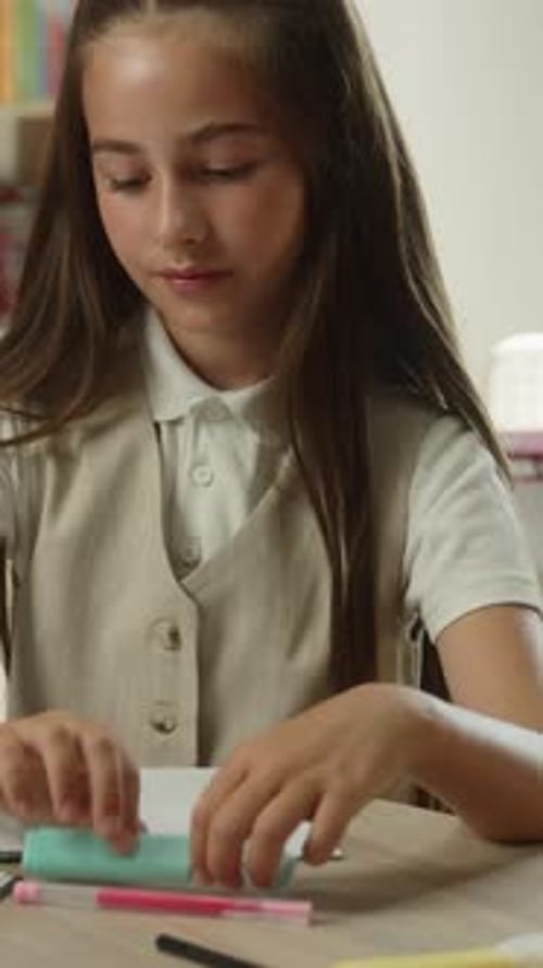 Dissatisfied Caucasian Little Girl Child Showing Thumb Down Writing Exam Inside School Classroom
