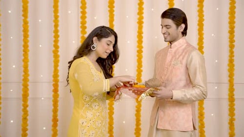 Woman Arranges Diwali Tray for Man in Traditional Clothing