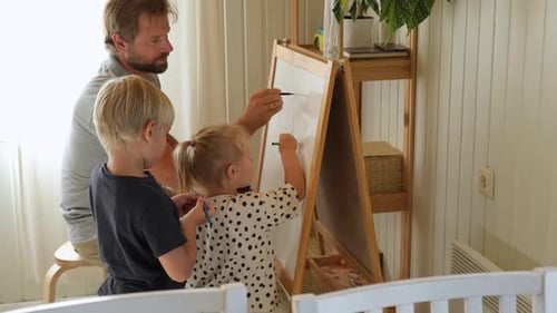 Father Drawing with Son and Daughter on Easel