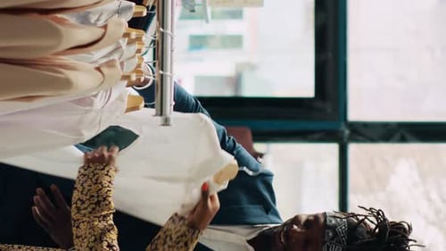 Three Adults Looking at Clothing Rack in Store