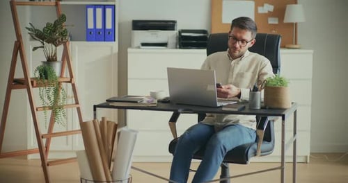 Man Working on Laptop at Home Office Desk
