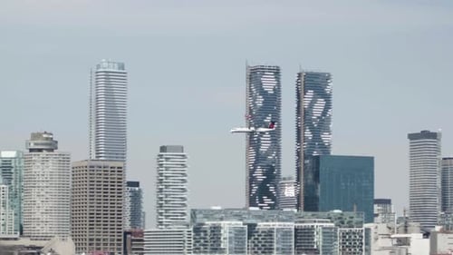 avion de ligne régional à turbopropulseurs volant avec le centre-ville de toronto en arrière-plan