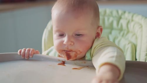 Baby with Food on Face in High Chair